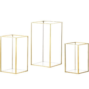Juego de farolillos portavelas de metal dorado y cristal trasparente.